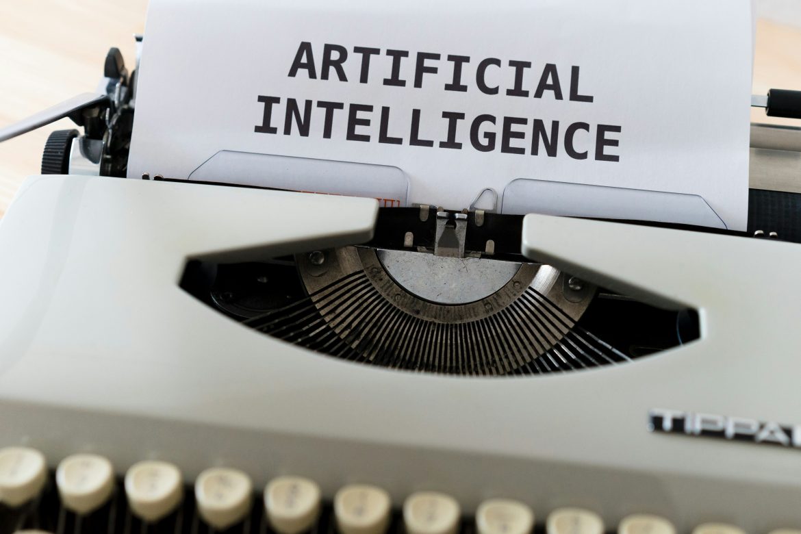 Une machine à écrire vintage avec une feuille de papier affichant les mots "ARTIFICIAL INTELLIGENCE", illustrant le passage de la gestion traditionnelle à la volonté d'automatiser sa comptabilité d'entreprise avec AI.