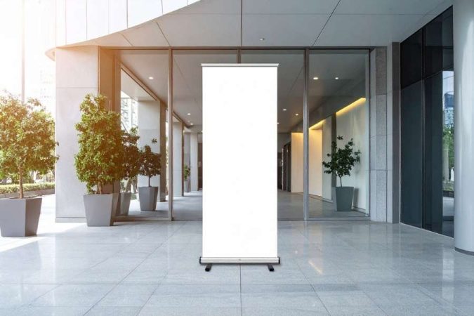 Un roll up xl blanc et vierge est installé au centre d'un hall d'accueil moderne.
