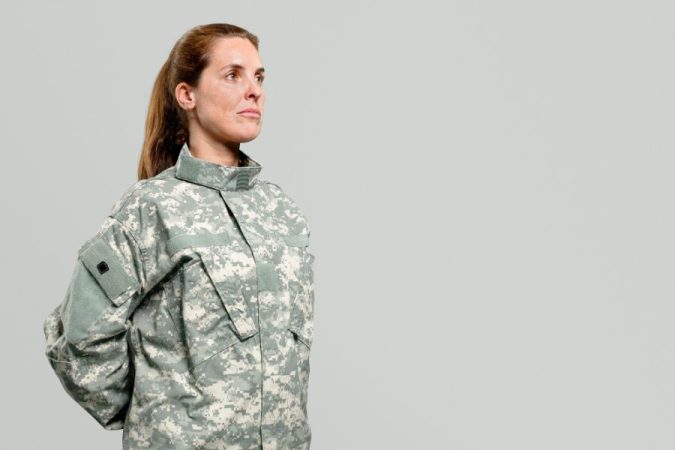 Femme militaire en uniforme camouflage se tenant droite, éligible à recevoir une médaille militaire.